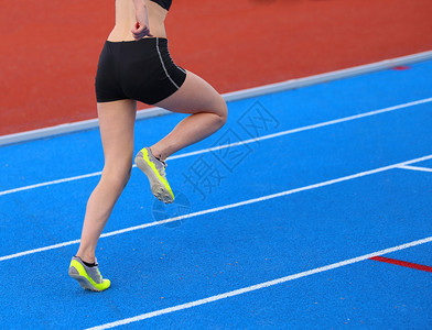 在田径跑道上奔跑的年轻女子图片