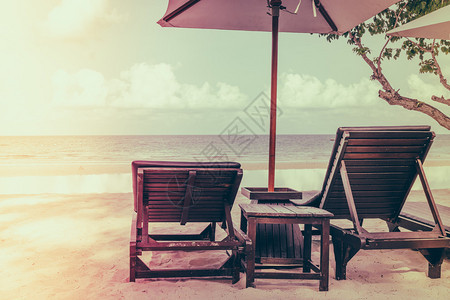 热带白色沙滩上带雨伞的漂亮沙滩椅图片