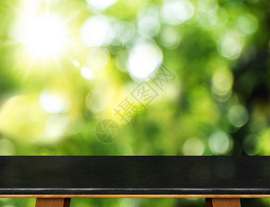 空荡的黑色大理石桌子和模糊的花园散景光背景模拟产品展示或蒙太图片