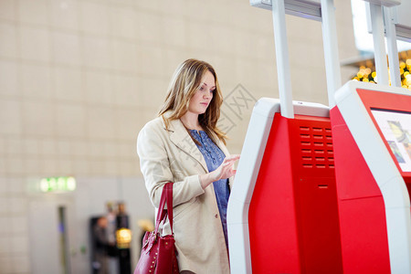 国际机场的年轻女士在电子终端检查时疲劳等待飞行图片