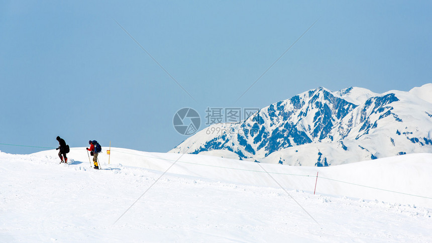 在雪上行走的滑雪者覆盖山图片