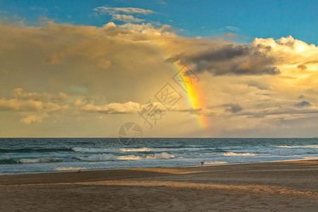 彩虹的尽头似乎在澳洲昆士兰金海岸市海滩上一个孤单的行走者看起来图片