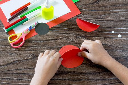 孩子用瓢虫做明信片儿童胶水纸制品木桌上的胶水纸剪刀儿童艺术项目背景图片