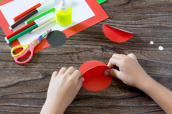 孩子用瓢虫做明信片儿童胶水纸制品木桌上的胶水纸剪刀儿童艺术项目图片