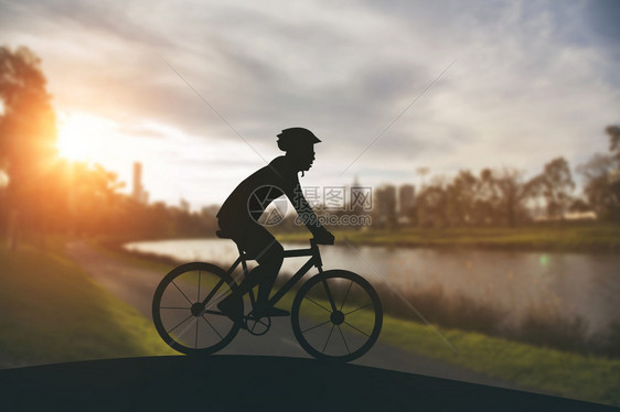 日落时在公共园骑摩登自行车图片