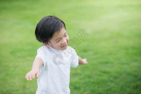 可爱的亚洲孩子在绿草地上玩耍图片