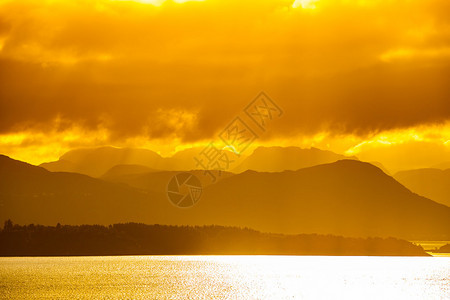 日出在挪威的山脉和大海图片