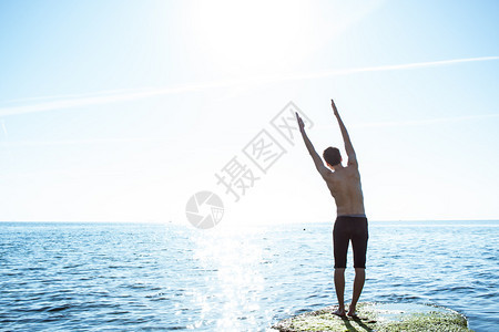 在早晨海背景的瑜伽锻炼图片