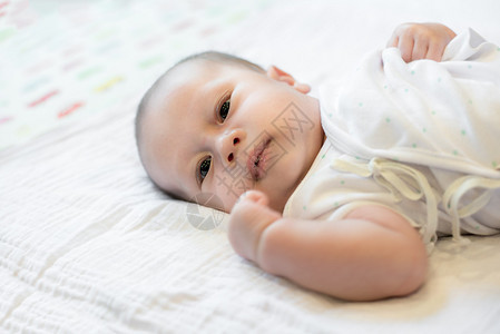 亚洲2个月婴儿有口水的新生婴儿躺图片