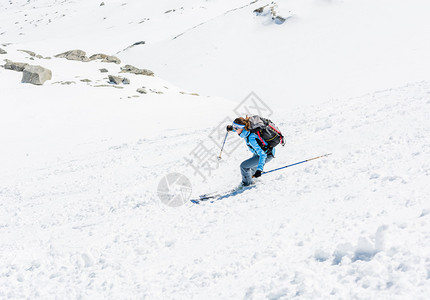 在陡峭的斜坡上滑雪的女滑雪者图片
