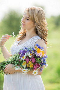 拥有天然花束的美丽的孕妇背景图片
