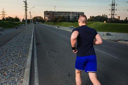 运动男子在路上跑步的近距离肖像图片