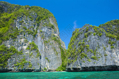 泰国海滩景与陡峭的石灰岩山丘和传统明亮的长尾船停车场玛雅湾皮岛李皮群岛甲米省的一部图片