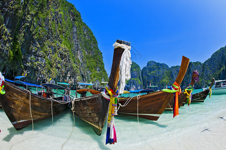 泰国海滩景与陡峭的石灰岩山丘和传统明亮的长尾船停车场玛雅湾皮岛李皮群岛甲米省的一部背景图片
