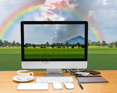 在美丽的自然观水稻田和彩虹的Mountain上带有计算机桌面的工作图片