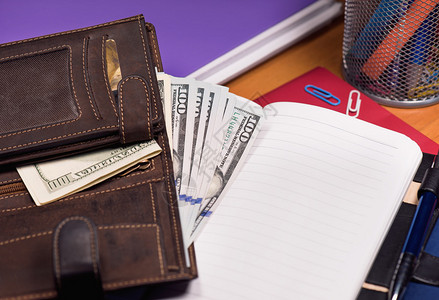 空的记事本和钱包桌上有美元钞票图片