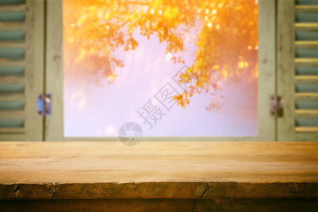 窗口中模糊的秋季自然面前的空桌准备用于产品图片