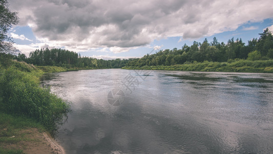 森林中平静的河流河两边都有反射和树木图片
