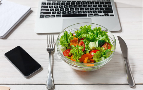 Salad碗移动电话和桌子上的注解板图片