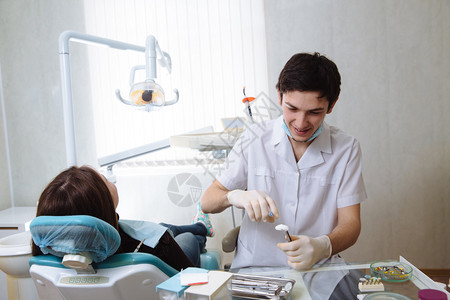 专业牙医对女病人牙科手术进行牙齿检查图片