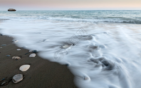 沙滩上黑沙和流水的海滨壁画造出漂亮的纹理图片