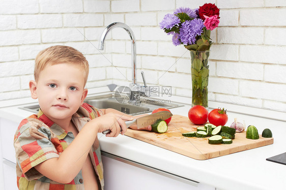 有趣的小男孩摆好餐桌吃饭在家吃健康的食物帅气的小男孩在厨房做饭图片