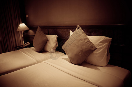床上的枕头和床头柜上的灯复古色调图片