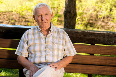长凳上的老人老男人一脸严肃退休第一年在宁静的气图片