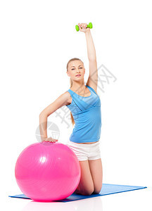 年轻女子与健身球和哑铃一起锻炼健身运动图片