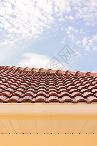 屋顶砖块雨沟和窗户在蓝天空背图片