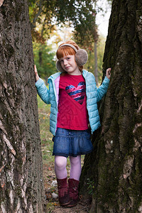 坐在公园树丛之间戴耳巾的小姜女图片