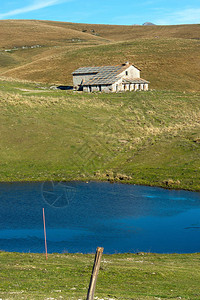 在Lessinia为养牛而遗弃的典型农舍Malga和小湖图片