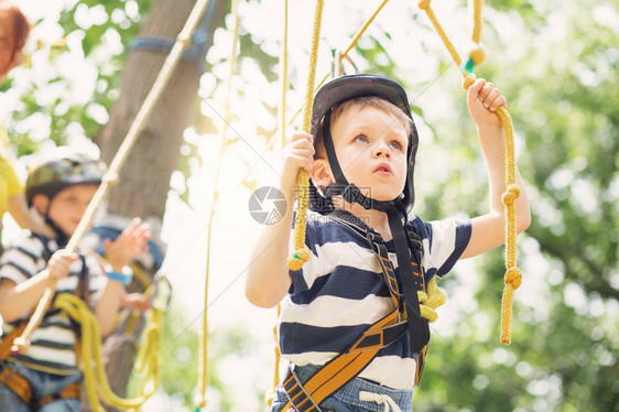 孩子们在冒险公园攀爬男孩喜欢在绳索课程冒险中攀爬攀爬高铁公园的孩子快乐的男孩在冒险公园玩耍图片