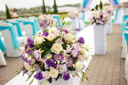 美丽浪漫的花朵在婚礼上设置了蓝色青色紫色洋红色的装饰用鲜花和布图片