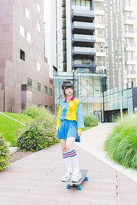 年轻美丽的亚洲千禧一代女在城市户外滑冰图片