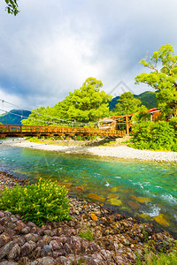 在日本长野Kamikochi的日本阿尔卑斯山村AzusaGawa河岸边的KappaBashi桥上空图片