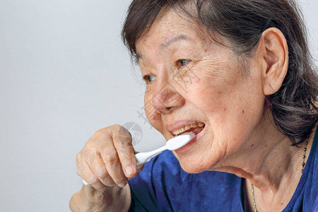 有牙刷的亚洲老年妇女牙科保健背景图片
