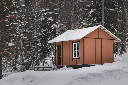 雪林中一座小木屋作为旅游庇护所或招待图片