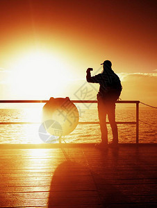 海鼹鼠的旅游照片远足者拍早晨海的照片秋雾码头木板上的游客图片