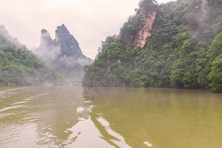 在湖南省Zhangjiajie附近的Wulingyuan采地区高石峰周围森林茂密的鲍丰湖景图片