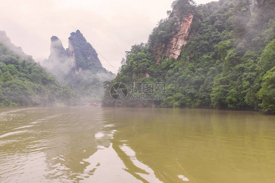 在湖南省Zhangjiajie附近的Wulingyuan采地区高石峰周围森林茂密的鲍丰湖景图片