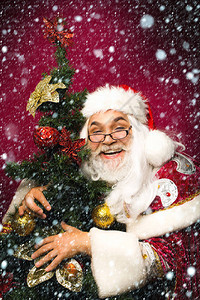 眼镜和红圣诞礼服里快乐的圣达克萨斯人拥抱着雪和背景图片