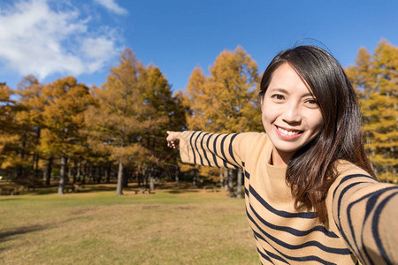 秋天的女人用相机拍照图片