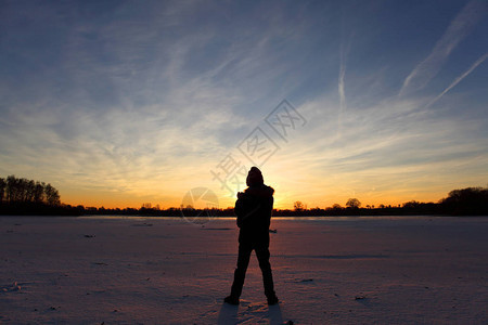 日落时湖边的小男孩图片