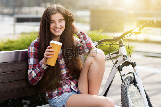 年轻女人喝咖啡的时候一个自行车之旅图片