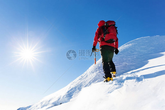 极端的冬季运动登山者的雪峰在顶部图片