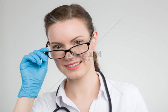 配备眼镜和听诊器的年轻女医生对照图片