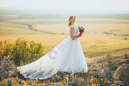 穿着婚纱的美丽新娘盛着一束花图片