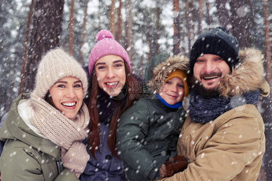 非常幸福的家庭在寒冷的冬日玩得开心的低角度家庭度假微笑和大笑图片