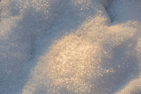 在关闭的雪背景夕阳下新鲜冬雪的表面图片